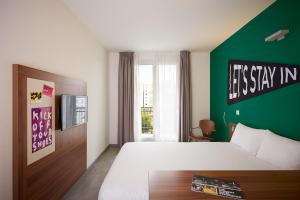 a bedroom with a large bed and a green wall at The Social Hub Paris La Défense in Puteaux