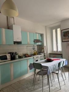 a kitchen with blue cabinets and a table and chairs at L’Albero Colorato in Candelo