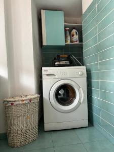 a washing machine in a bathroom with a basket at L’Albero Colorato in Candelo +20 photos