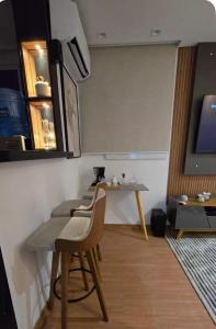 a room with a table and chairs and a television at Belo Apartamento Com Piscina in Várzea Grande