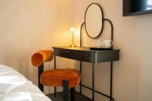 a vanity with a mirror and a chair next to a bed at Roza Hotel in Enfield