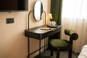 a room with a table and a chair and a mirror at Roza Hotel in Enfield +9 photos