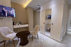 a living room with chairs and a table and a tv at AMIR PLAZA hotel in Akmechetʼ +21 photos