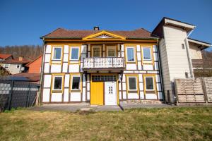 a large house with a yellow and white at Bergsonnen-Stuben in Bad Lauterberg