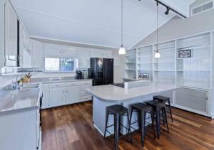 a large white kitchen with a large island with bar stools at Pawnee 2 - Newly Renovated Duplex in Chattanooga +24 photos