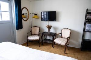 a bedroom with two chairs and a table with a tv at Hotel Ribe in Ribe +15 photos