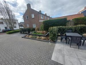 a patio with a table and chairs in front of a building at 't Vakansie'uus in Serooskerke