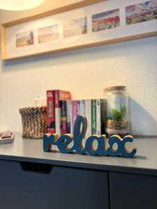 a shelf with books on a table with the word roland at L'Appart avec terrasse - centre historique in Barr