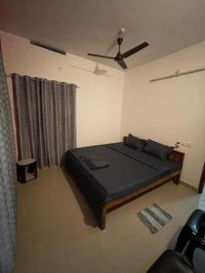 a bedroom with a bed and a ceiling fan at Southern Cliff House in Varkala