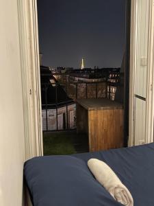 a room with a bed and a window with a view at Eiffel Tower View Apartment in Paris