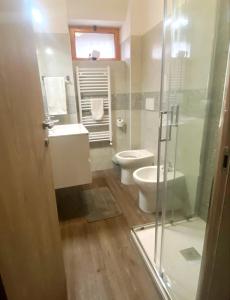 a bathroom with a toilet and a glass shower at S1 Home Sila in Camigliatello Silano +7 photos