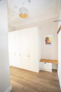 a white kitchen with white cabinets and a wooden floor at Seaview in Worthing