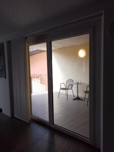 a sliding glass door leading to a patio with a table at Casa Edo in Ponte Tresa