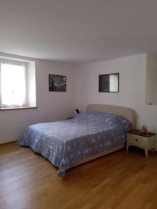 a bedroom with a bed and a wooden floor at Casa Edo in Ponte Tresa