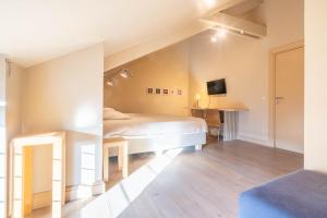 a bedroom with a bed and a tv on the wall at Domein Marsnil in Heers