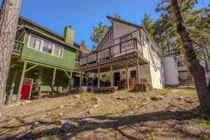 a green and white house with a tree at Gonzalez Cabin in Running Springs
