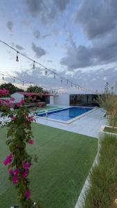 a backyard with a swimming pool and flowers at Ghala Farm in Adh Dhayd