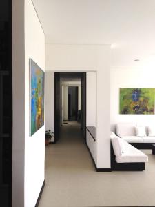 una sala de estar con sofá y una pintura en la pared en Casa Campestre Condominio Bellavista, en Tobia