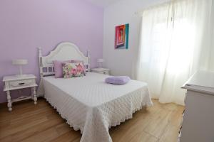 a bedroom with a bed with a white bedspread and purple pillows at Casa Oliveira in Silves +32 photos