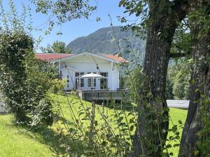 a white house with a porch and a tree at Chalet Alpenlicht in Oberstdorf +31 photos