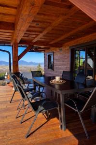 a dining room with a table and chairs on a deck at Drevenica Lesanka in Belá