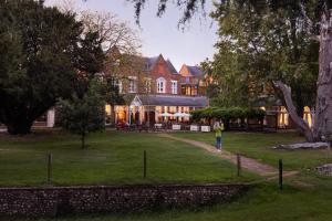 a person standing in front of a large house at Coulsdon Manor Hotel and Golf Club in Croydon