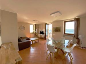 a living room with a glass table and white chairs at Apartment 4 in Salò