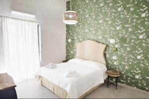 a bedroom with a bed and a green and white wall at Corso Vittorio Elegant Suites Lipari in Lipari