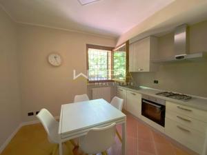 a kitchen with a white table and white chairs at Apartment 4 in Salò +19 photos