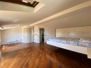 a large bedroom with a large bed and a wooden floor at Apartment 4 in Salò