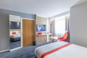 a hotel room with a bed and a tv at Holiday Inn Express London Croydon by IHG in Croydon +89 photos