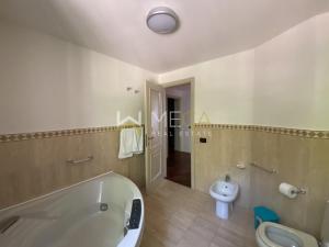 a bathroom with a bath tub and a toilet at Apartment 4 in Salò