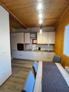 a kitchen with white cabinets and a wooden ceiling at Kuća za odmor Goranski mir in Mrkopalj