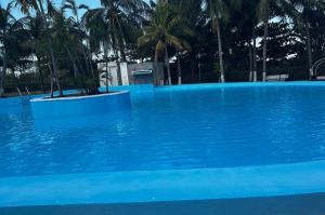 a blue swimming pool with palm trees in the background at Sunlight Hotel in Cancún