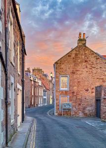 an old brick building on the side of a street at Aqua Vista- seafront cottage Cellardyke in Anstruther
