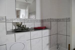 a bathroom with a sink and a mirror and a tub at Ferienwohnung Zentral in Langenargen +9 photos