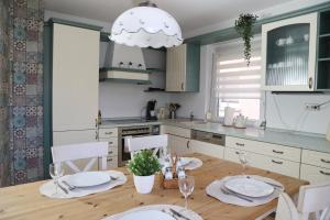 a kitchen with a wooden table with chairs and a chandelier at Ferienwohnung Zentral in Langenargen
