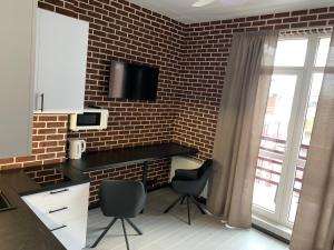a kitchen with two chairs and a brick wall at Стильна смарт-квартира in Odesa