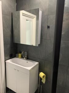 a bathroom with a white sink and a mirror at Стильна смарт-квартира in Odesa