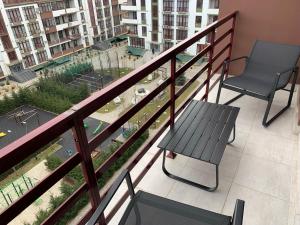 a balcony with a bench and a chair on it at Стильна смарт-квартира in Odesa