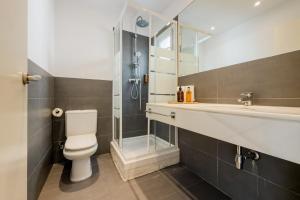 a bathroom with a toilet and a glass shower at Palau de la Musica Apartments in Barcelona +48 photos