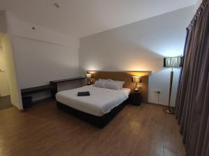 a hotel room with a bed and a lamp at Sofea Roomstay Hotel in Kota Bharu