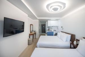 a bedroom with two beds and a flat screen tv at Ciel de Mer in Busan