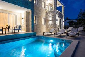 a swimming pool in front of a building at Villa Bella Vista with Pool and Seaview in Labinci