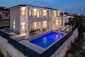 a villa with a swimming pool in front of a house at Villa Bella Vista with Pool and Seaview in Labinci