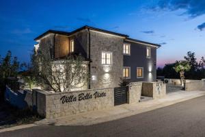 a house with a stone wall in front of a street at Villa Bella Vista with Pool and Seaview in Labinci