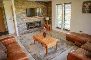 a living room with a couch and a fireplace at Oak Lodge in Knighton