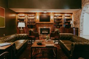 a living room with leather couches and a fireplace at The St Nicholas Hotel in Albany