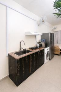 a kitchen with a sink and a washing machine at Sahara View Guest House Prime Location on the Dubai Sharjah Border in Sharjah