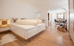 a white bedroom with a bed and a living room at Gästehaus Babel in Pfronten